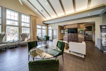 a clubhouse filled with furniture and a large window  at Avellan Springs Apartments, North Carolina